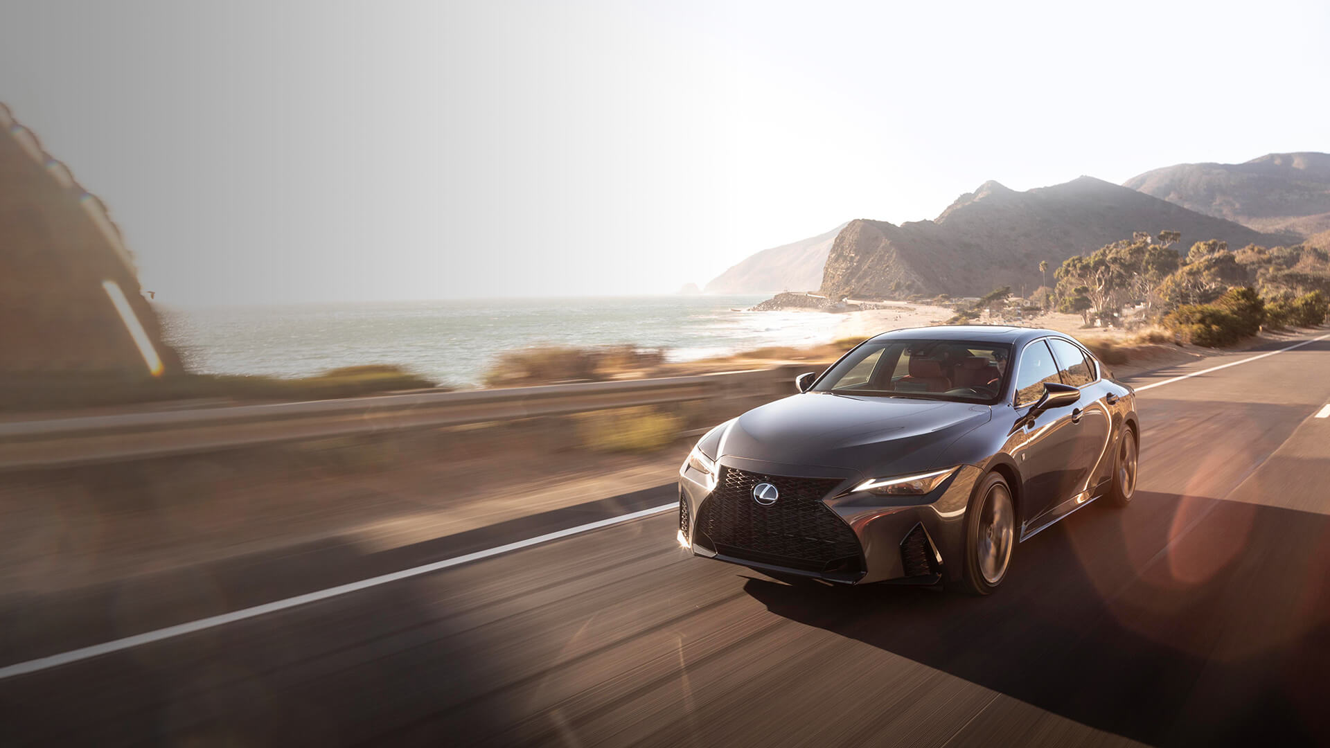 Grey Lexus IS being driven on the road.